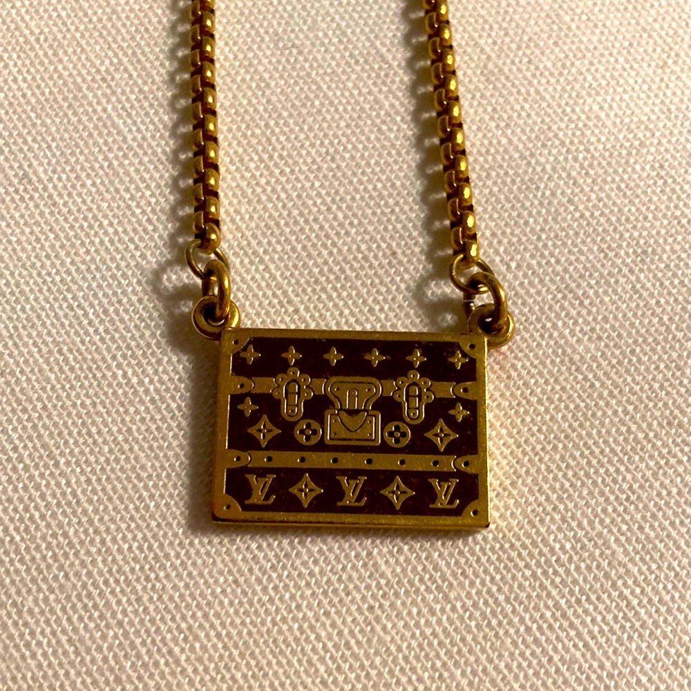 Louis Vuitton logo trunk charm on a necklace in gold